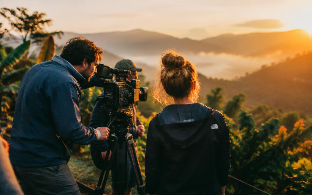Equipo de filmación en un cafetal al atardecer